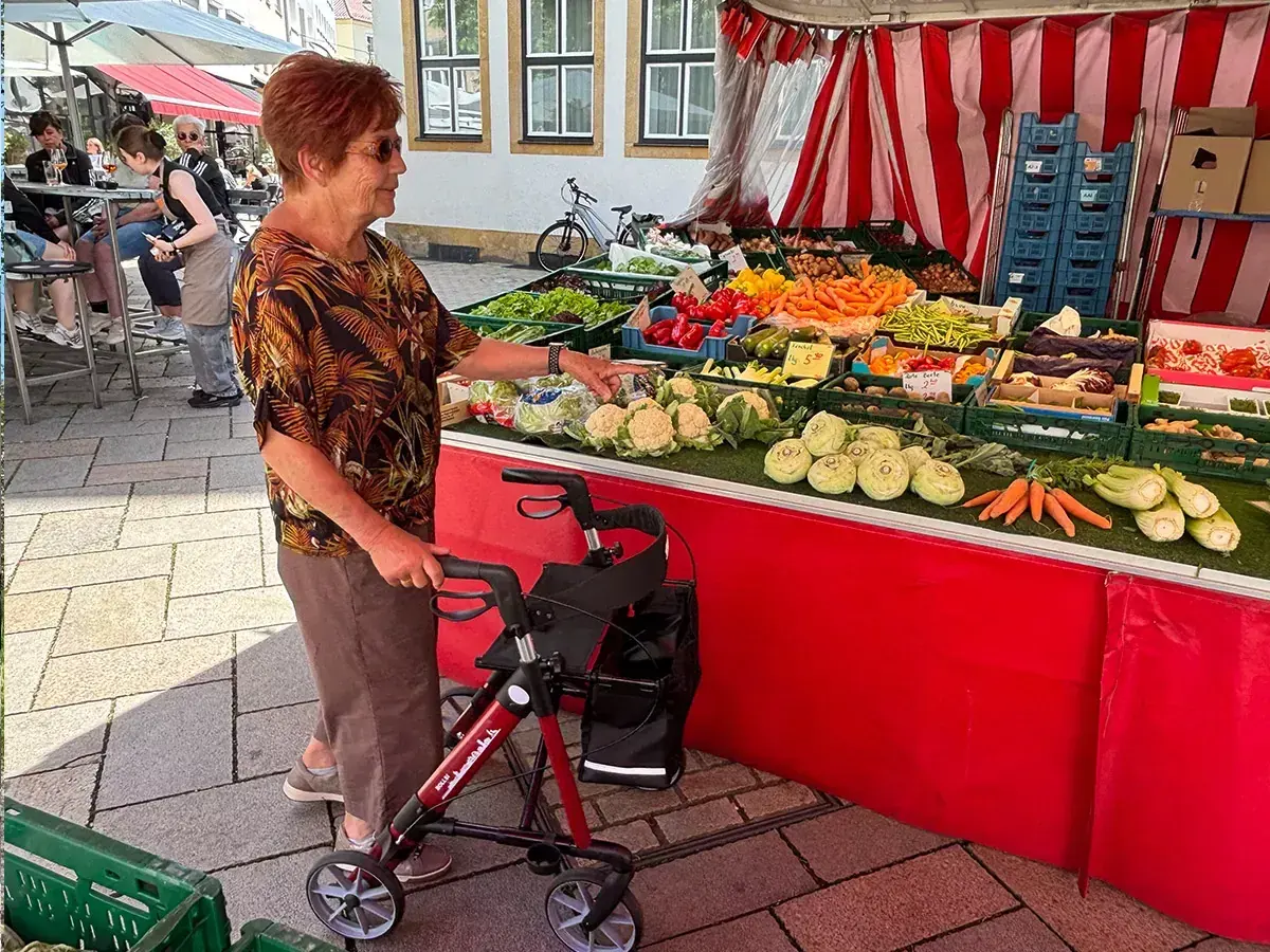 Kundin mit Rollator beim Einkauf an einem Marktstand in Bielefeld