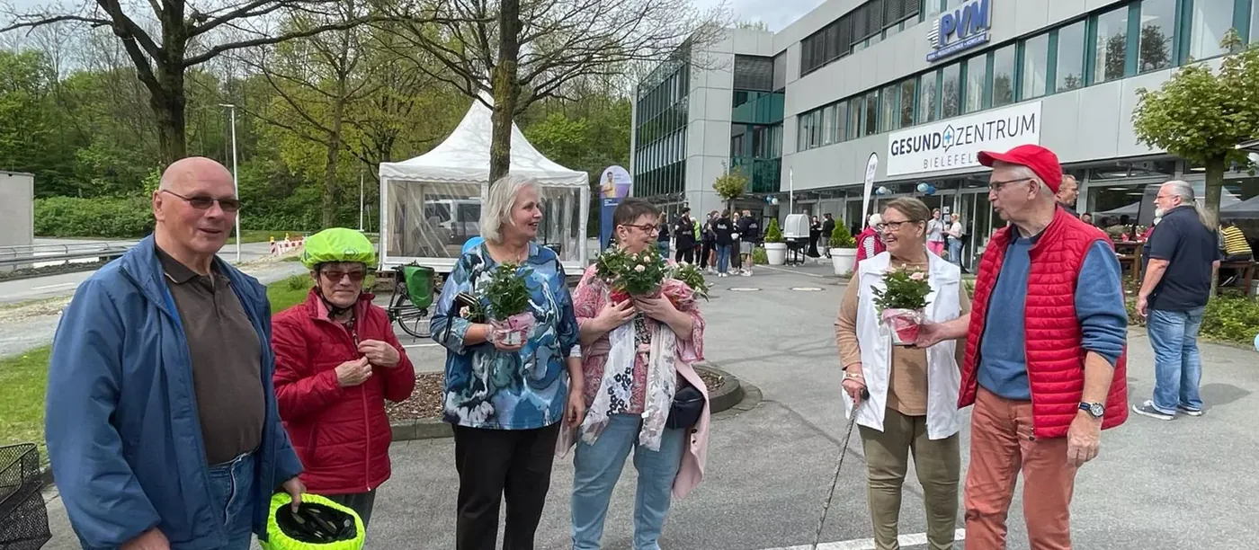 Besucherinnen und Besucher mit Rosenpflanzen vor dem GesundZentrum beim Frühlingsfest 2024