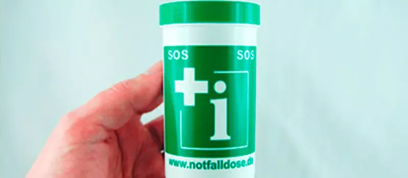 Eine grüne Notfalldose in der Hand