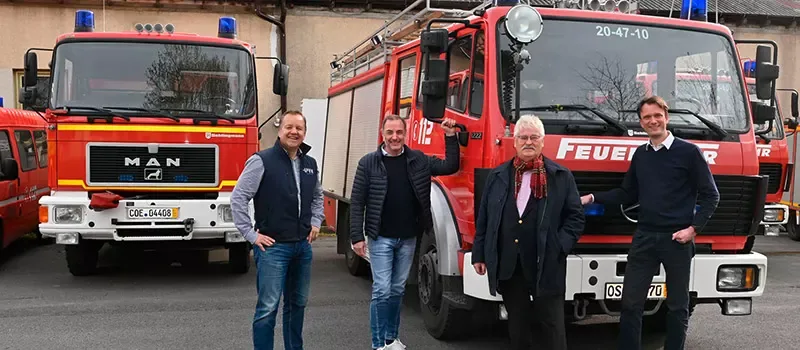 Helfer vor einem Feuerwehrfahrzeug für den Hilfstransport in die Ukraine
