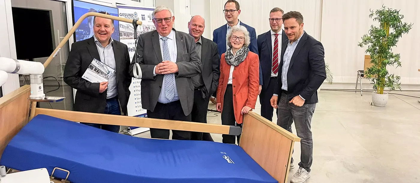 Markus Wendler mit NRW-Gesundheitsminister Karl-Josef Laumann und Gästen an einem Pflegebett