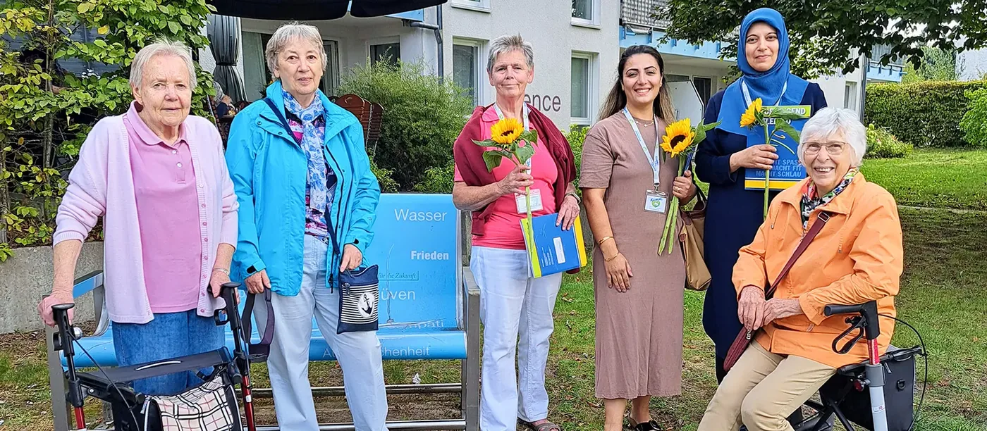 Teilnehmende des Spaziertreffs Brackwede mit Rollatoren vor dem Blauen Haus