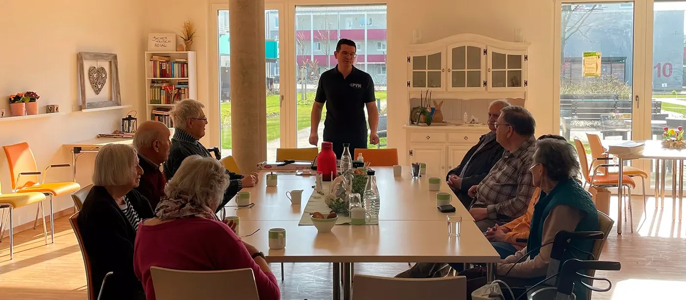 Gäste des Nachbarschaftscafés Cafe3b an Tischen im Wohncafé