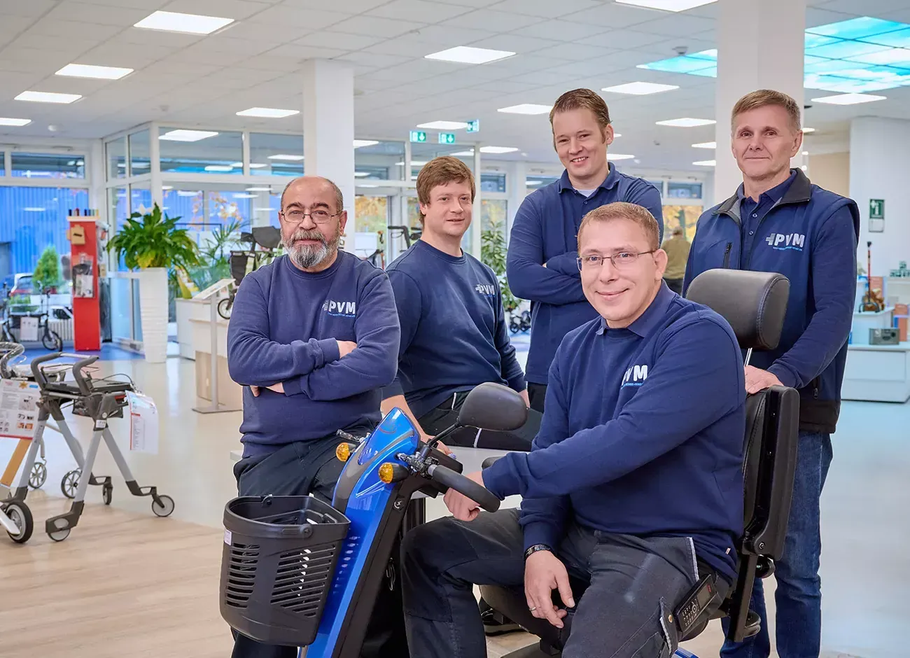 Das Team aus Betrieb und Lager von PVM mit einem Elektromobil in der Ausstellung